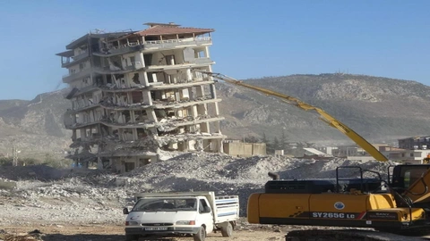 Ağır hasarlı bina iş makinasının tek dokunuşuyla yerle bir oldu