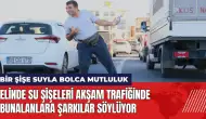 Elinde su şişeleri akşam trafiğinde bunalanlara şarkılar söylüyor